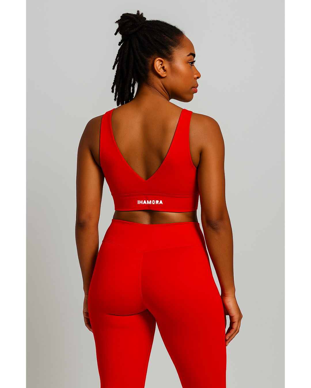 Woman wearing a red sports bra and leggings with 'IHAMORA' branding on a light gray background