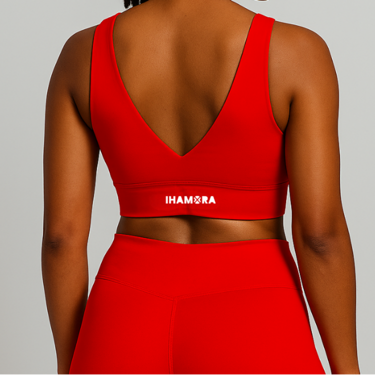 Woman wearing a red sports bra and leggings with 'IHAMORA' branding on a light gray background