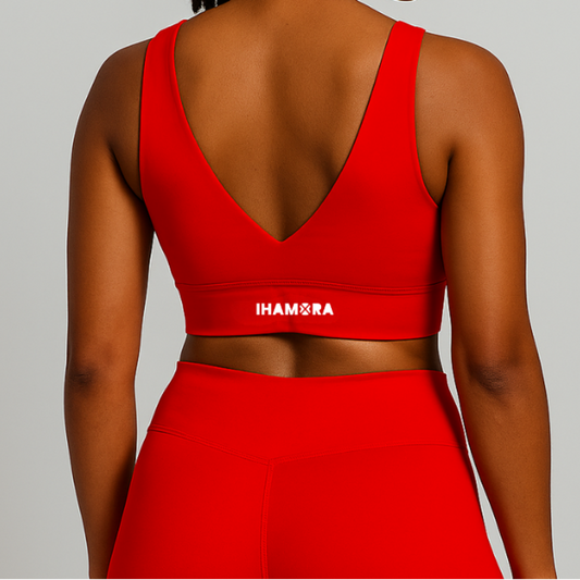 Woman wearing a red sports bra and leggings with 'IHAMORA' branding on a light gray background