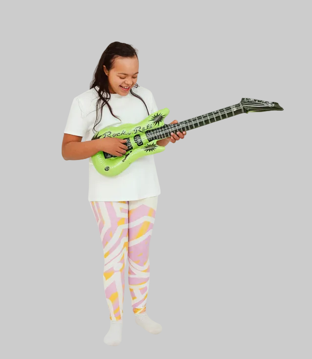 Child playing with a toy guitar on a white background