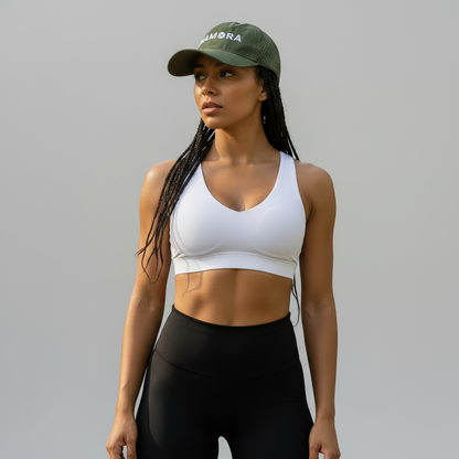 Woman in athletic wear standing on a path with trees in the background. wearing IHAMORA cap