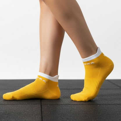 Pair of yellow socks with white tops on a white background