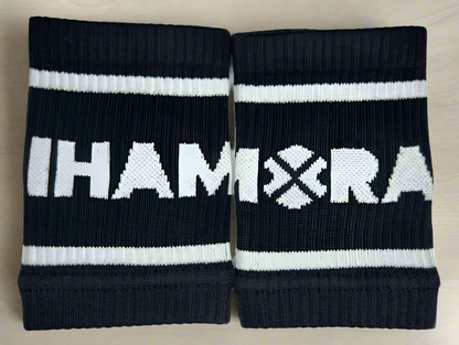 A pair of black essentials sports wristbands with the IHAMORA logo in white.