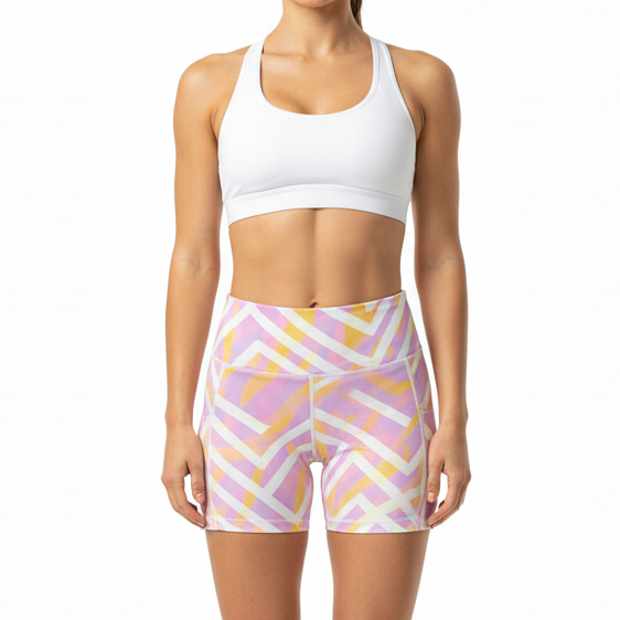 Woman wearing a white sports bra and patterned shorts on a white background