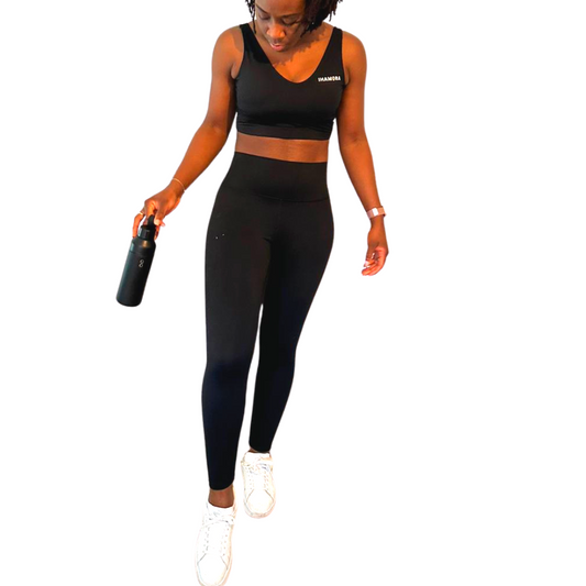 Woman wearing IHAMORA Essential Black High-Waisted Leggings with pockets and supportive waistband.