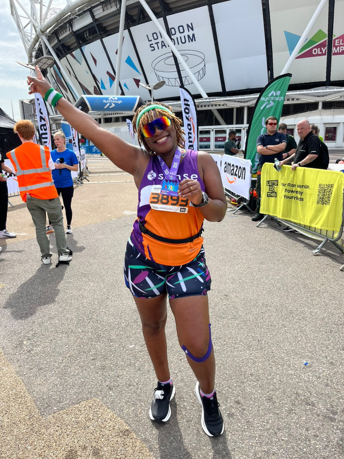 Person celebrating after a marathon event at the London Stadium, wearing high-waisted bamboo gym shorts by IHAMORA