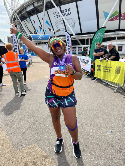 Person celebrating after a marathon event at the London Stadium, wearing high-waisted bamboo gym shorts by IHAMORA