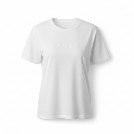 Woman wearing a white t-shirt with text and blue jeans sitting on the floor.