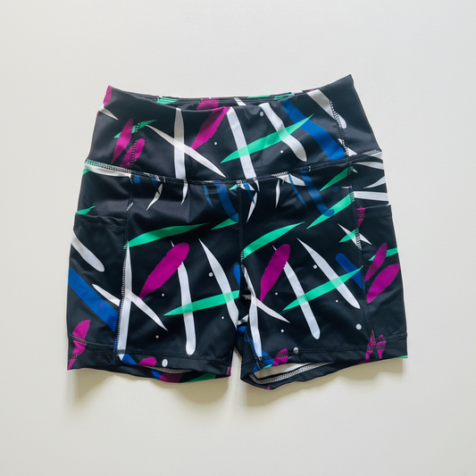 high-waisted bamboo gym shorts by IHAMORA with colorful abstract pattern on a black background