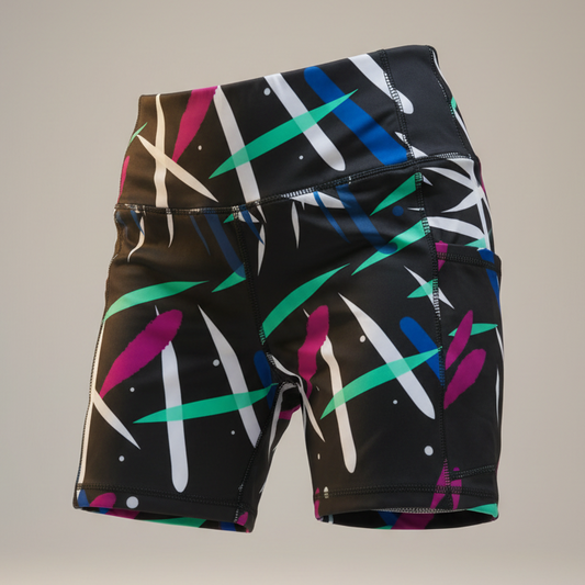 Black athletic shorts with colorful abstract pattern on a gray background