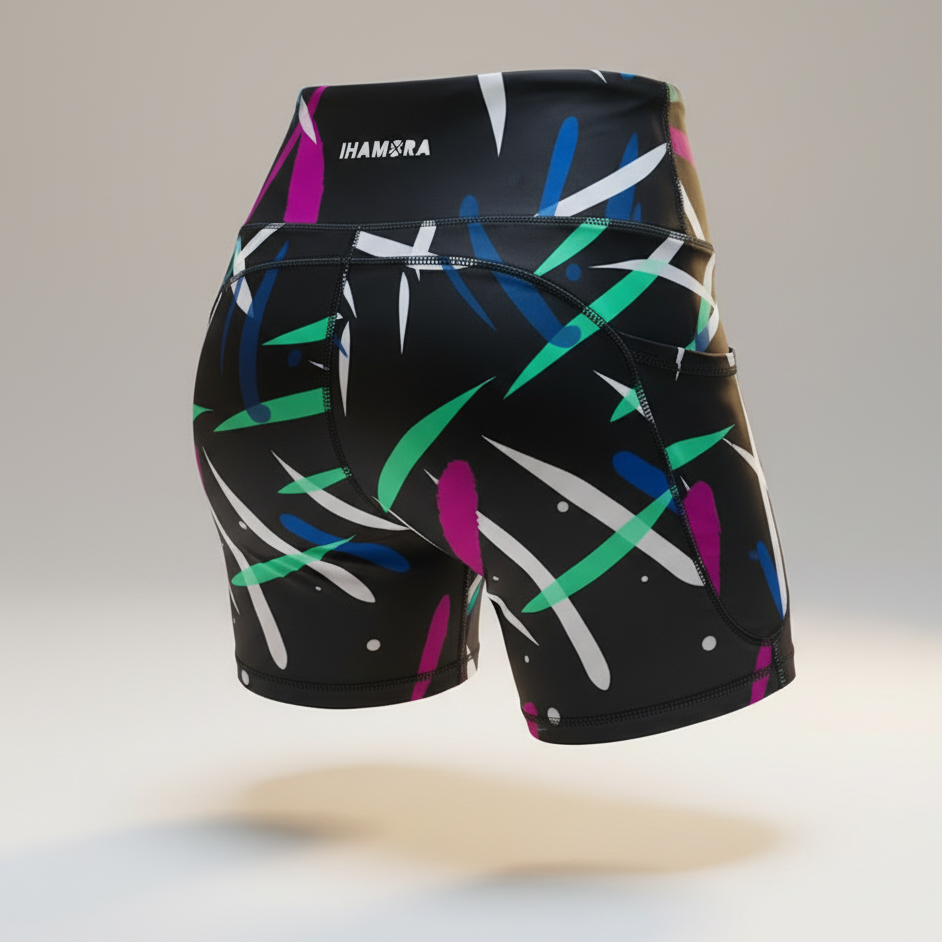 Black athletic shorts with colorful abstract pattern on a light gray background
