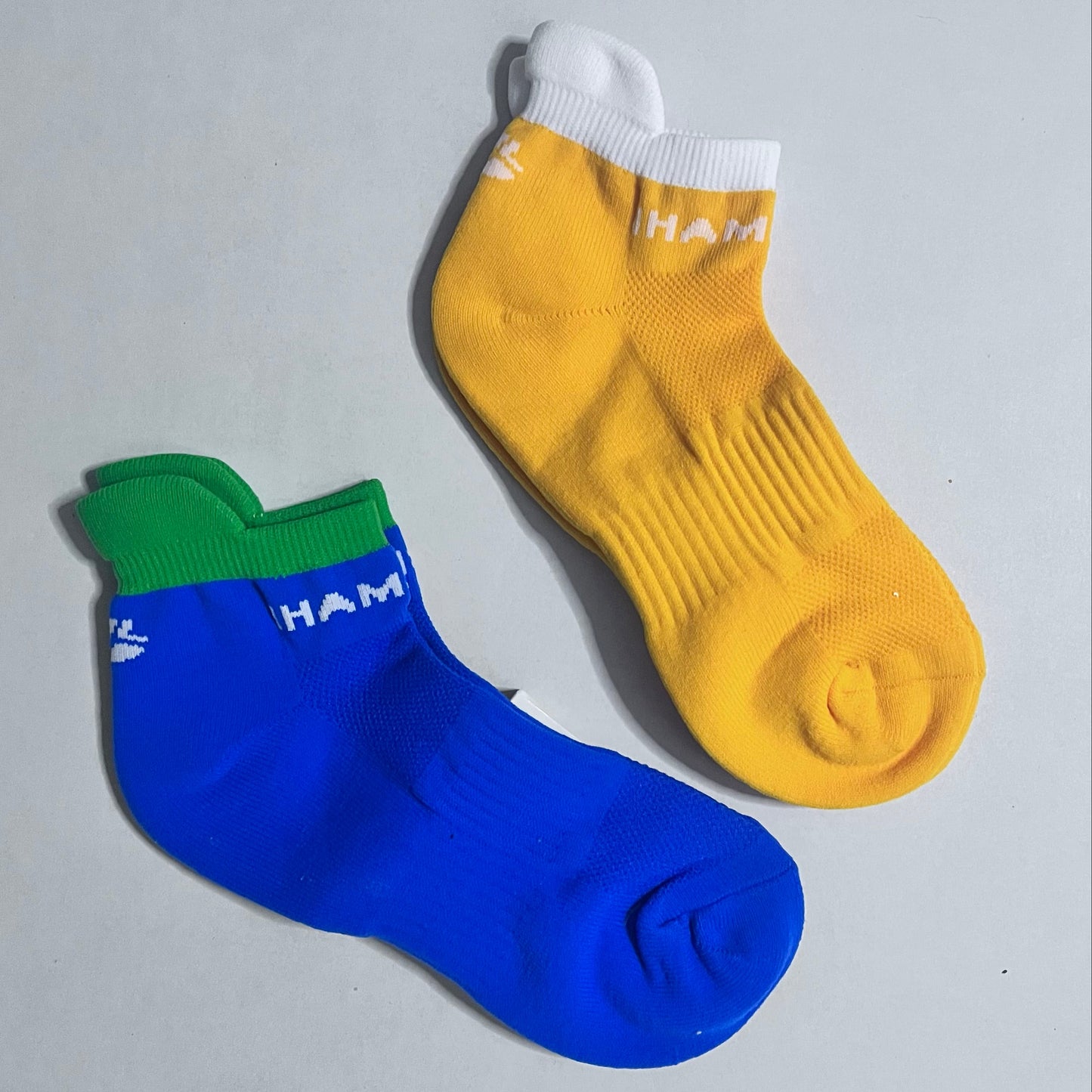 Yellow and blue socks with visible branding on a gray background
