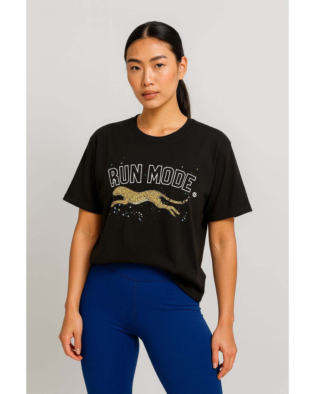 Woman wearing a black t-shirt with 'RUN MODE' and a leaping cat graphic on a plain background and IHAMORA Icon