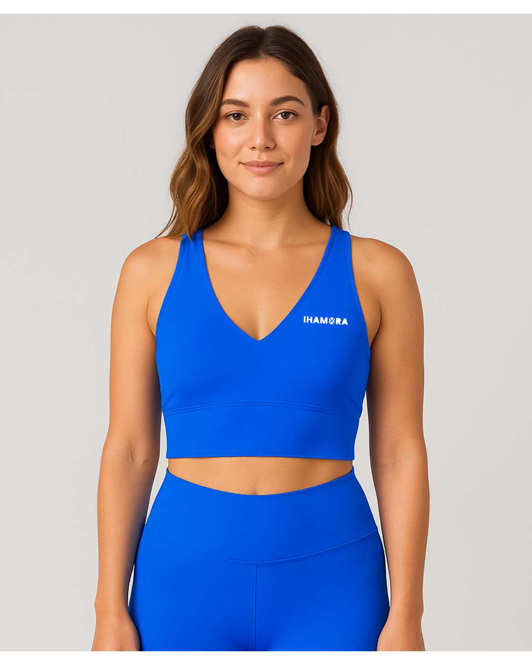 Woman wearing a V NECK blue sports bra with 'IHAMORA' branding on a gray background