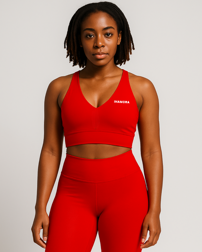 Woman wearing a red sports bra and leggings with 'IHAMORA' branding on a light gray background