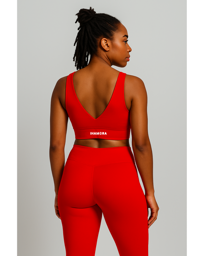 Woman wearing a red sports bra and leggings with 'IHAMORA' branding on a light gray background